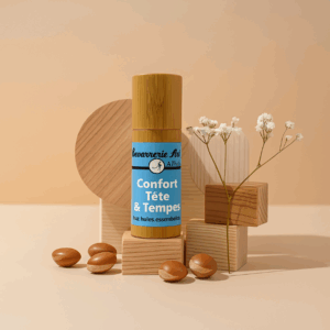 Roll-on vert d’un produit “Confort Tête & Tempes” sur bois, entouré de petites billes et de fleurs séchées.
