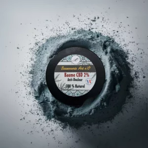 Baume 2% soulage douleur, disponible dans un pot noir posé sur poudre bleue, étiqueté Savonnerie Art n’O, 100% naturel.